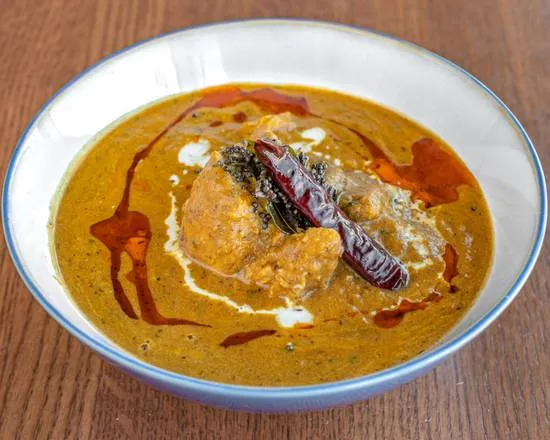 Goat curry in a rich spiced gravy with dried red chilli and a swirl of cream at Shehnai Restaurant in Hamilton, ON